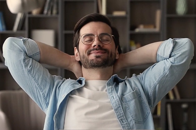 Hombre con gafas sonriendo con ojos cerrados