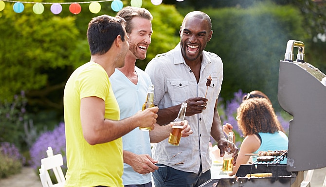 Group Of Men Cooking On Barbeque At Home