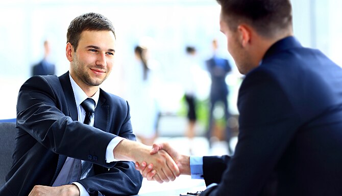 Two business colleagues shaking hands during meeting