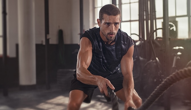 Joven atlético haciendo algunos ejercicios de fitness con una cuerda