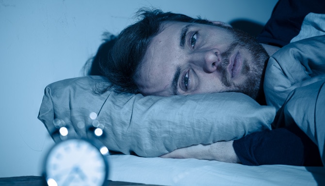 Hombre con problemas de insomnia por sudoración nocturna