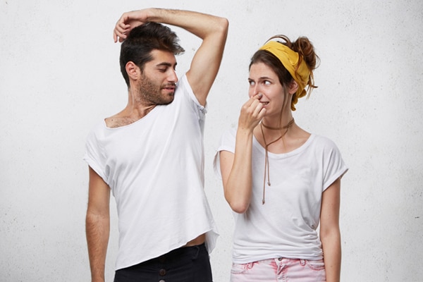 Chica oliendo el mal olor de un chico Chica oliendo el mal olor de un chico